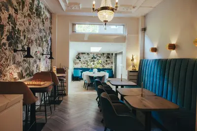 a restaurant with tables and chairs and a window at Boutique Hotel Asterisk, a family run hotel in Amsterdam