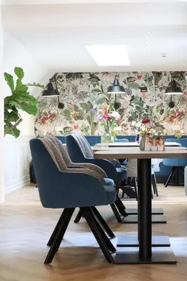 a dining room with a table and chairs and a wall at Boutique Hotel Asterisk, a family run hotel in Amsterdam
