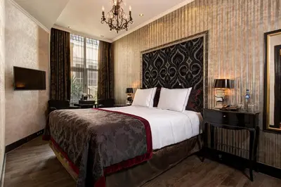 a hotel room with a bed and a chandelier at The Toren Amsterdam, by The Pavilions in Amsterdam