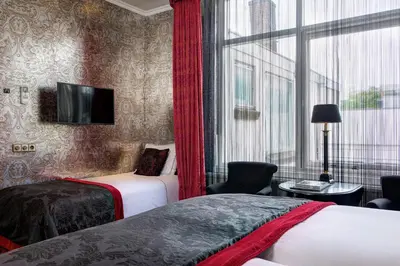 a hotel room with two beds and a window at The Toren Amsterdam, by The Pavilions in Amsterdam