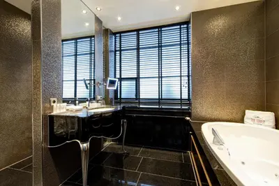 a bathroom with a tub and a sink and a bath tub at The Toren Amsterdam, by The Pavilions in Amsterdam