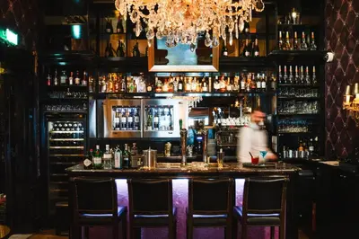 a bar with a man standing behind a counter at The Toren Amsterdam, by The Pavilions in Amsterdam