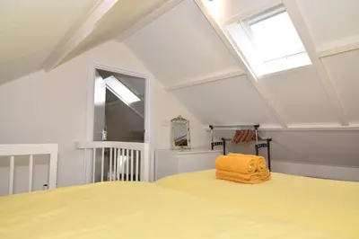 a bedroom with a yellow bed and a skylight at Casa Feliz in Egmond aan Zee