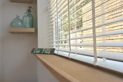a window sill with a sign that reads tea flux at Casa Feliz in Egmond aan Zee