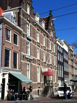 a large brick building with people sitting outside of it at OZO Hotels Armada Amsterdam in Amsterdam