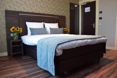 a bedroom with a large bed with a blue blanket at OZO Hotels Armada Amsterdam in Amsterdam