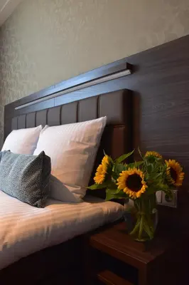 a bedroom with a bed with a vase of sunflowers on a table at OZO Hotels Armada Amsterdam in Amsterdam