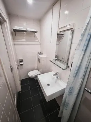 a white bathroom with a sink and a toilet at Hotel Vondel Garden in Amsterdam
