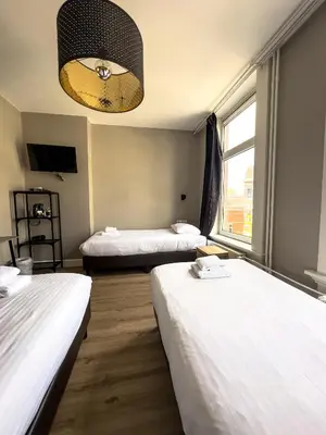a hotel room with two beds and a chandelier at Hotel Vondel Garden in Amsterdam