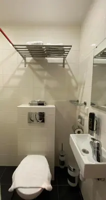 a white bathroom with a sink and a toilet at Hotel Vondel Garden in Amsterdam