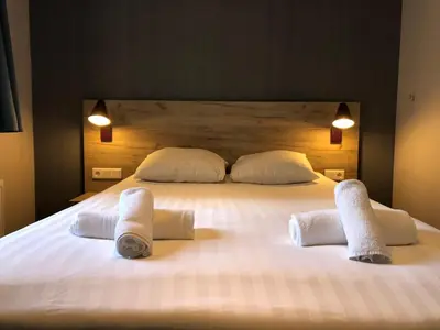 a large white bed with two towels on it at Facade Hotel Amsterdam in Amsterdam