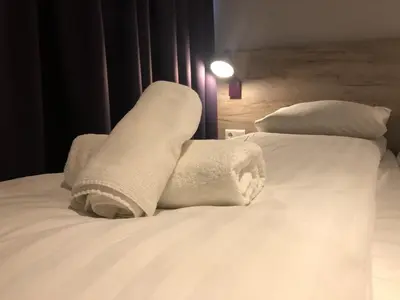 a pile of towels sitting on top of a bed at Facade Hotel Amsterdam in Amsterdam