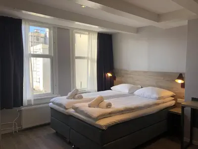 a bedroom with a large bed with two stuffed animals on it at Facade Hotel Amsterdam in Amsterdam
