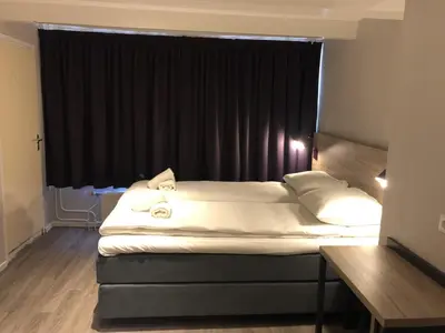 a bed in a room with a black window at Facade Hotel Amsterdam in Amsterdam