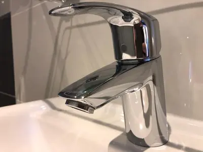 a chrome sink faucet on a white sink at Facade Hotel Amsterdam in Amsterdam