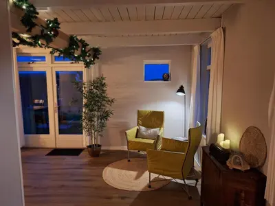 a living room with a yellow chair and a window at Uniek vakantiehuis - nabij molen, meer, strand & stad' in Hoorn