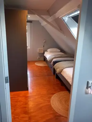 a room with two beds in a attic at Uniek vakantiehuis - nabij molen, meer, strand & stad' in Hoorn