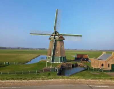 a windmill in the middle of a field at Uniek vakantiehuis - nabij molen, meer, strand & stad' in Hoorn