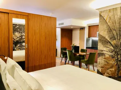 a hotel room with a bed and a table and chairs at Chasse Residency Hotel in Amsterdam