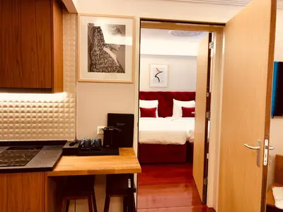 a room with a kitchen and a bedroom with a bed at Chasse Residency Hotel in Amsterdam