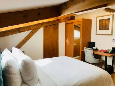 a bedroom with a white bed and a desk at Chasse Residency Hotel in Amsterdam