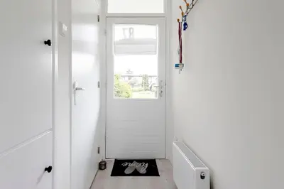 a hallway with a white door and a dog mat at Sea Shell apartment in Zandvoort