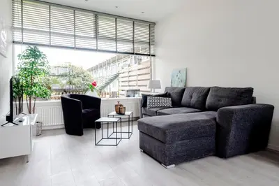 a living room with a couch and a chair at Sea Shell apartment in Zandvoort