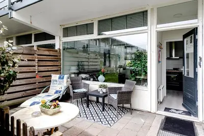 a patio with chairs and a table and a window at Sea Shell apartment in Zandvoort
