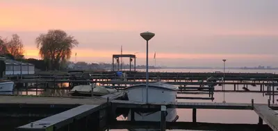 a marina with boats in the water at sunset at Amsterdam / Loosdrecht Rien van den Broeke Village in Loosdrecht