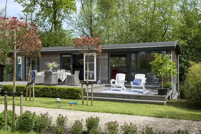a tiny house in the garden with chairs and a table at Amsterdam / Loosdrecht Rien van den Broeke Village in Loosdrecht