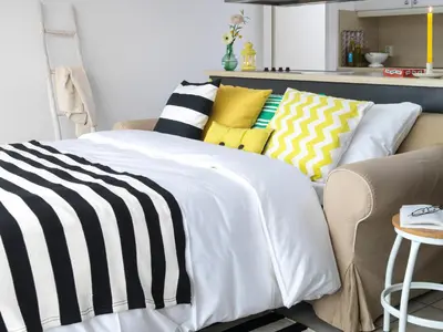 a room with a bed and a couch with pillows at Amsterdam / Loosdrecht Rien van den Broeke Village in Loosdrecht