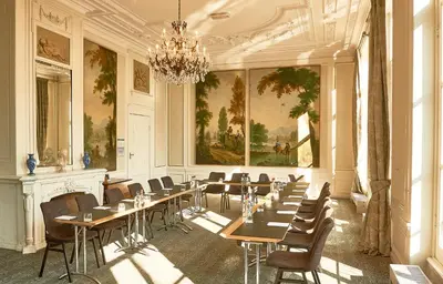 a dining room with tables and chairs and a chandelier at Landgoed Oud Poelgeest - Leiden in Oegstgeest