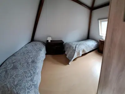 a small bedroom with two beds and a window at Onder de Boomen in Bergen