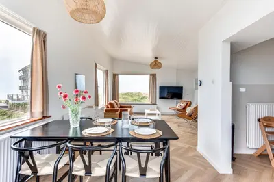 a living room with a table and chairs at Vernieuwd Zeezicht Villa Zee Luxe in Bergen aan Zee