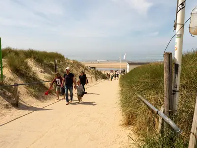 a group of people walking down the beach at Vernieuwd Zeezicht Villa Zee Luxe in Bergen aan Zee