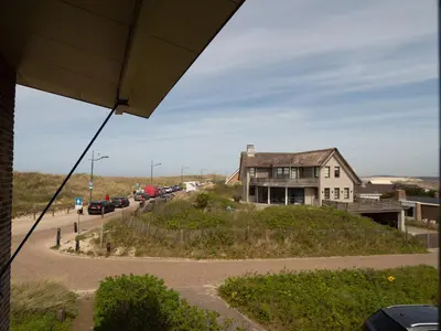 a house sitting on top of a hill next to a road at Vernieuwd Zeezicht Villa Zee Luxe in Bergen aan Zee