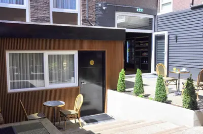 a patio with chairs and a table in front of a building at Huygens Place Amsterdam in Amsterdam