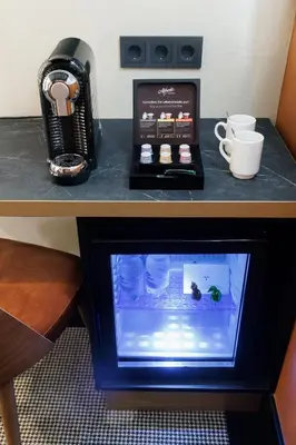 a desk with a coffee maker and a monitor on it at Huygens Place Amsterdam in Amsterdam