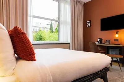 a hotel room with a bed and a window at Huygens Place Amsterdam in Amsterdam