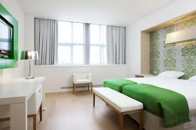 a hotel room with a large bed and a desk at NH Amsterdam Noord in Amsterdam