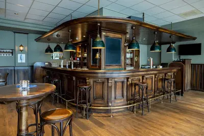 a bar in a restaurant with tables and stools at NH Amsterdam Noord in Amsterdam