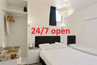 a white bedroom with a open sign on the wall at Hotel-Chao NL 24 hours open in Utrecht