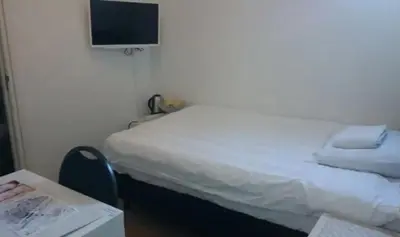 a room with two beds and a tv on the wall at Hotel-Chao NL 24 hours open in Utrecht