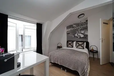 a bedroom with a bed and a large window at Hotel Zeespiegel in Zandvoort