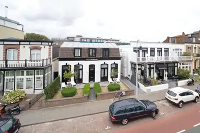 a street with cars parked in front of buildings at Hotel Zeespiegel in Zandvoort