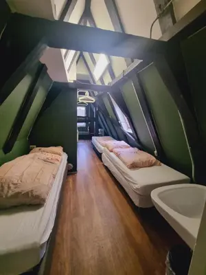 two beds in a room with a sink and a bathroom at Amsterdam Downtown Hotel Canal View in Amsterdam