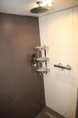 a bathroom with a shower with wooden walls at Amsterdam Downtown Hotel Canal View in Amsterdam