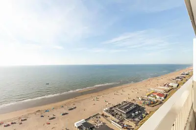 a view of the beach from the balcony of a condo at Ocean BreezeApartment: WakeUp 2 Sound of the Waves in Zandvoort