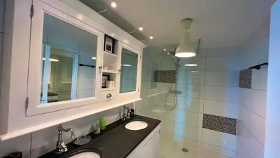 a bathroom with a sink and a mirror and a shower at Ocean BreezeApartment: WakeUp 2 Sound of the Waves in Zandvoort