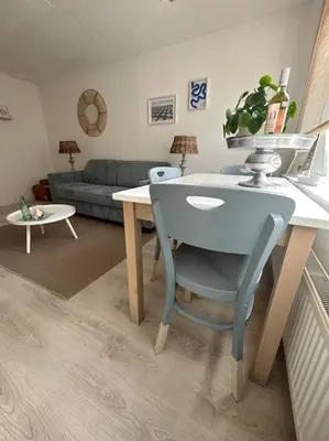 a table and a chair in a living room at Have a nice stay! - Voilà! - beach at 500m- free parking in Noordwijk aan Zee